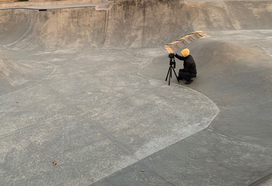 Amir Zaki crouches to snap photos of a skate park at dawn.