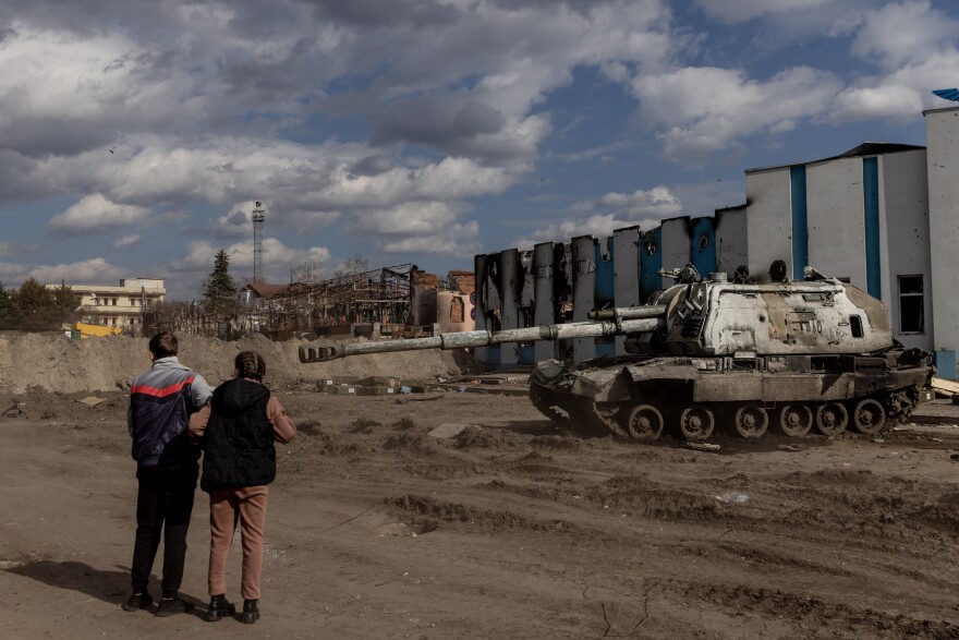 <strong>March 29:</strong> Residents look at a destroyed Russian tank close to the central train station that was used as a Russian base in Trostyanets.