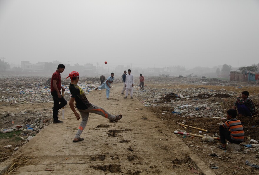Youths play cricket in a trash field near where Zainab's body was found on Jan. 9.