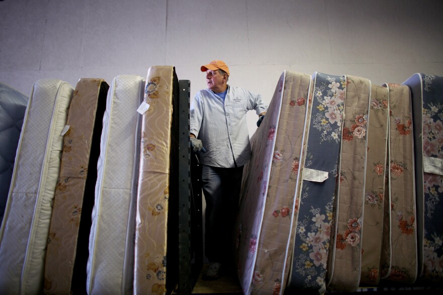 Volunteers from Epworth Furniture Ministry prepare donated mattresses for distribution in Perrysburg, Ohio. A tight-knit group of volunteers and assistance agencies in the Toledo area help incoming refugees and local families in need.