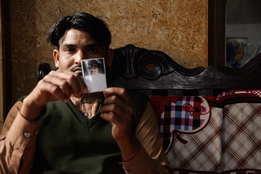 Mustafa, a barber in Kasur, holds the only image he has of his daughter, Noor-Fatima. About a year ago, he sent the 6-year-old to buy milk. She was found the next day, raped and killed, her body dumped in a construction site.