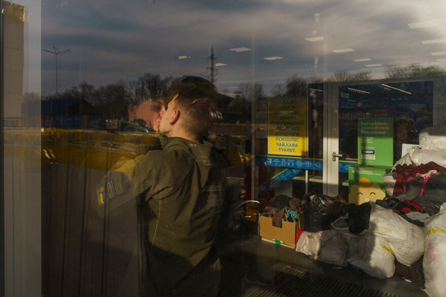 <strong>March 29:</strong> Lina and Vlad, both volunteers, kiss each other at the registration center in Zaporizhzhia.