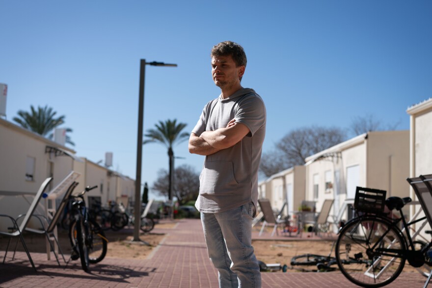 Avidor Schwartzman, 38, stands in front of a trailer park for survivors of the Oct. 7 attack, in Shefayim, Israel, on Tuesday. His family was moved from a hotel to one of these prefab homes two weeks ago. His wife's parents, Cindy and Igal Flash, were killed in the attack.