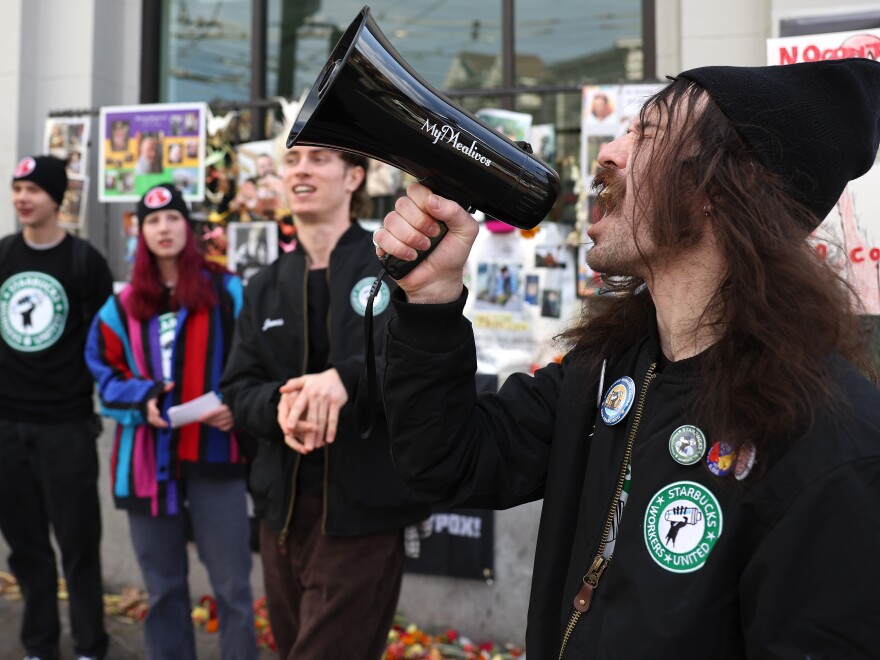 Striking Starbucks worker Kyle Trainer uses a megaphone outside of a Starbucks coffee shop during a national strike on November 17, 2022 in San Francisco, California.