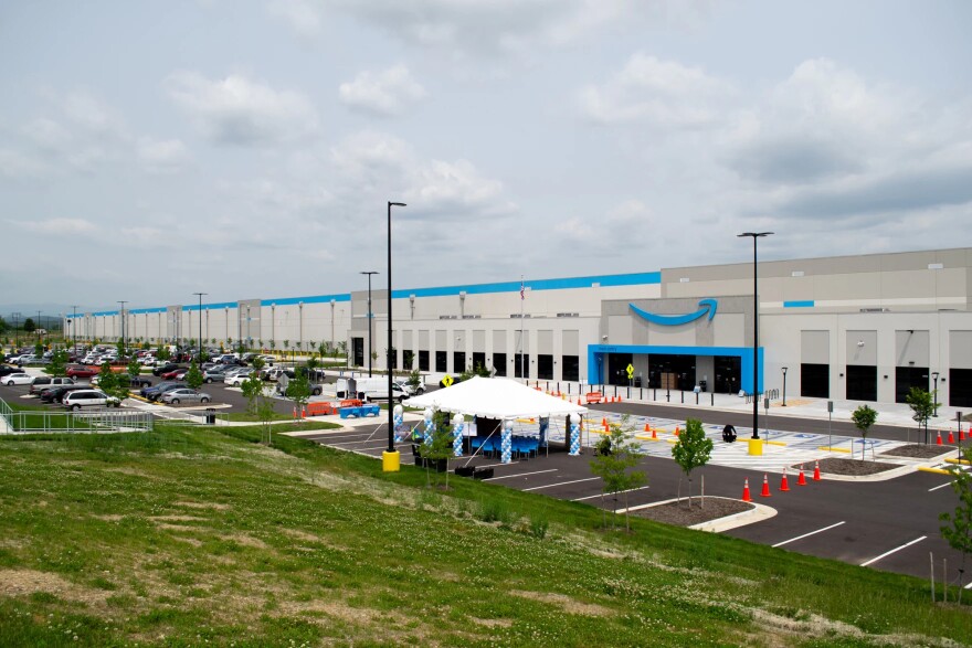 A large, blue and gray building. The amazon logo is above the door