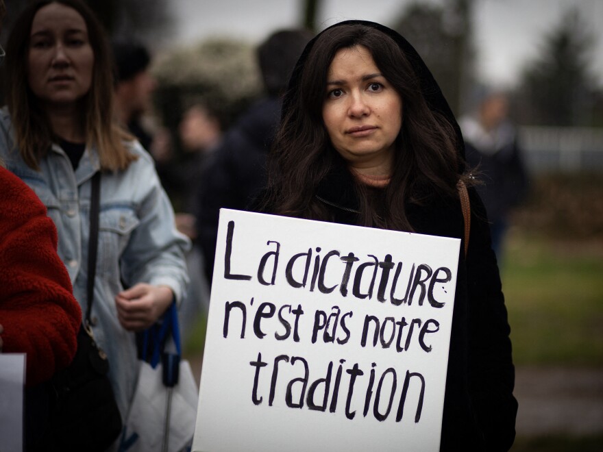 A woman holds a placard reading dictatorship is not our tradition during a gathering of Navalny's supporters near the Russian Embassy in France in Paris on March 17, 2024, during Russia's presidential election.