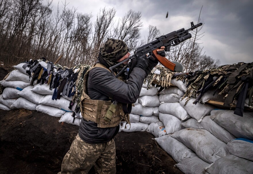 <strong>March 31:</strong> A Ukrainian serviceman shoots at a Russian drone with an assault rifle from a trench at the front line east of Kharkiv.