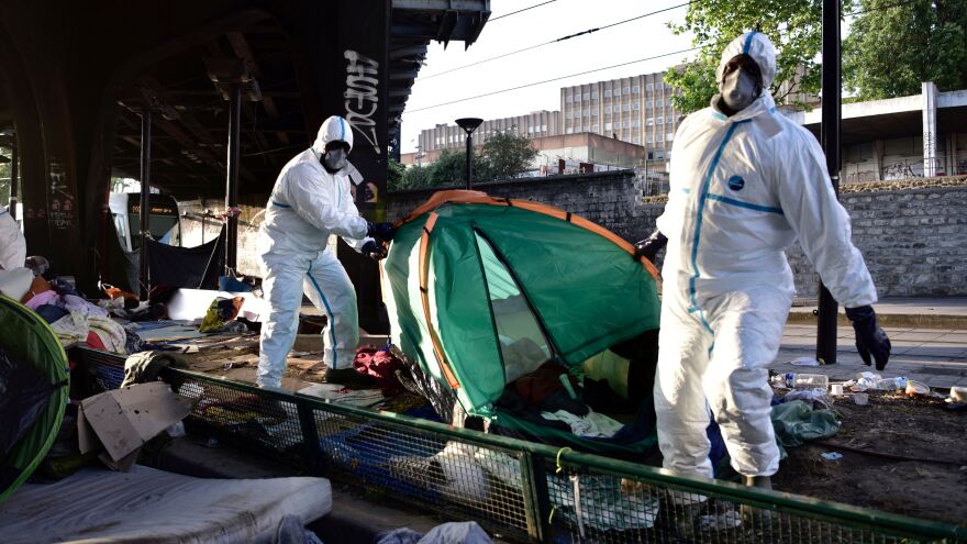Workers remove a tent after law enforcement evacuated the makeshift camp it was in on Tuesday.