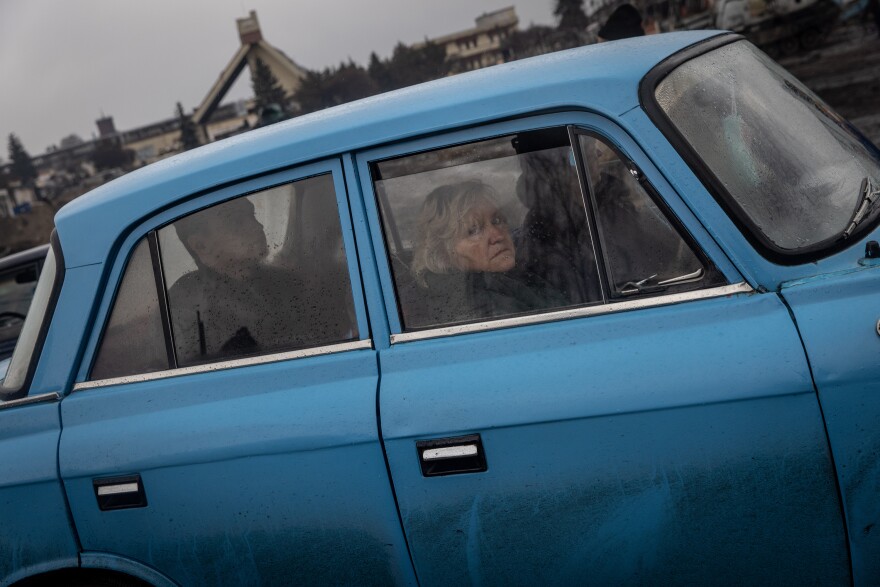 <strong>March 30:</strong> People in a car look at a destroyed Russian tank close to the central train station that was used as a Russian base in Trostyanets.