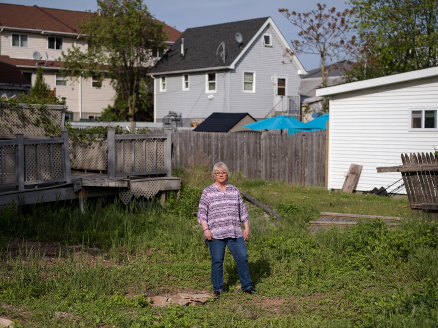Like many other homeowners, Ann Marie Cianci — standing near her abandoned house on Staten Island, N.Y. — has been unable to move back home. After paying flood insurance for 32 years, she received only $60,000 out of her $250,000 policy.