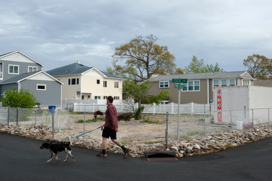 Life in the neighborhood continues on around the empty lot where Doug Quinn's house used to stand in Toms River, N.J.