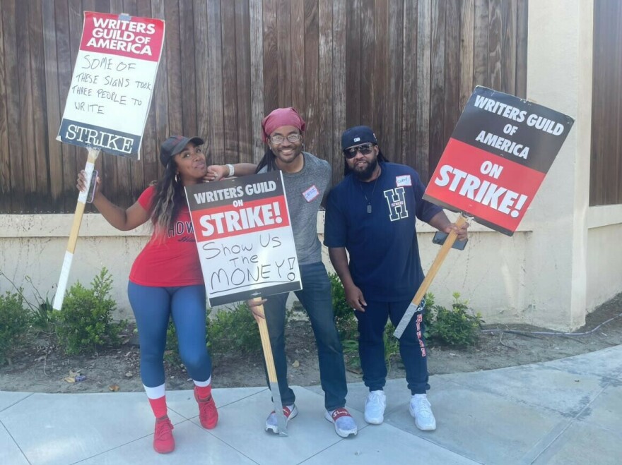 Striking writer Lanett Tachel (L) says, "we're not here to rewrite a machine." She's pictured with Cedi Ali Raja (center) and Corey Grant (R).