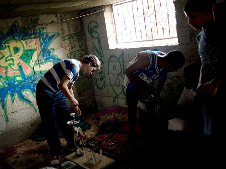 At a refugee camp in Gaza, Palestinian teenagers hang out in a graffiti-covered warehouse July 28. They give classes on the art of graffiti and break dancing.