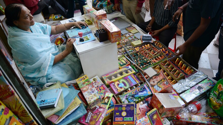An Indian shopkeeper sits at her firecracker shop in New Delhi on Oct. 9, as India's top court ordered a temporary ban on the sale of firecrackers in New Delhi ahead of the Diwali festival.