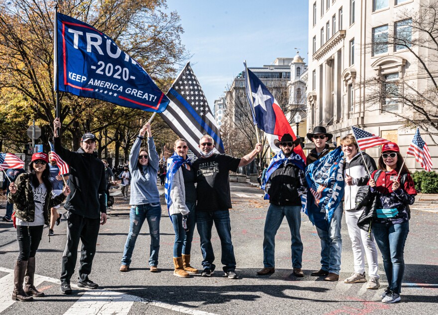 Trump supporters raise their flags at the Million MAGA March.