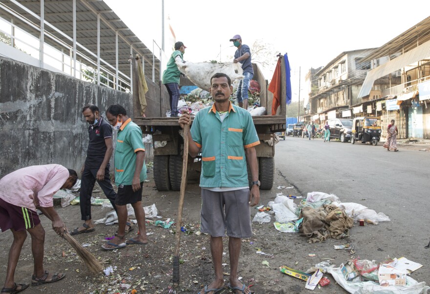 Sanitation worker Ramesh Solanki cleans the streets outside India's Palghar railway station. "I get up every morning at 5:30, and I see news about the vaccines on TV," he says. "I don't know about any controversies. I just know I'm proud to be part of this." As a sanitation worker, he was among the first Indians eligible to get the coronavirus vaccine.