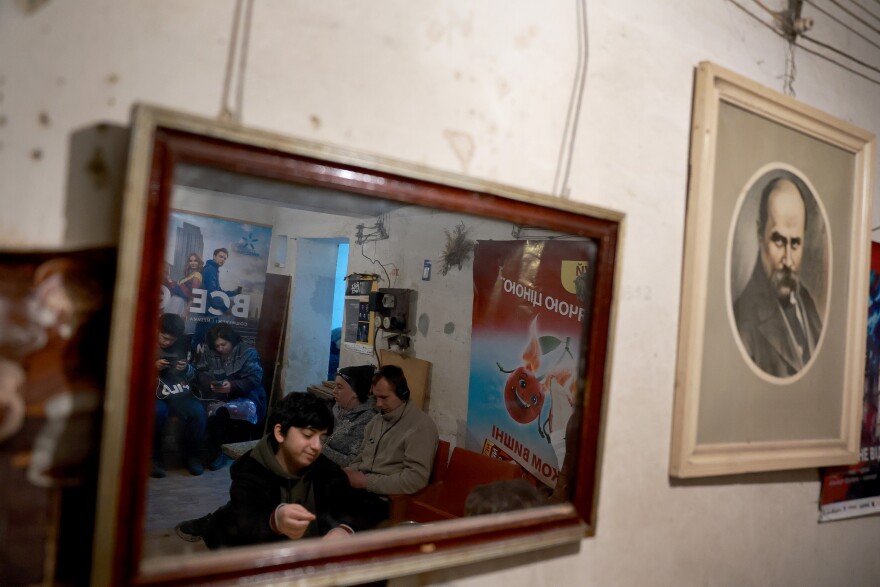 <strong>March 29:</strong> People sit in a bomb shelter after an air raid siren sounded in Lviv.