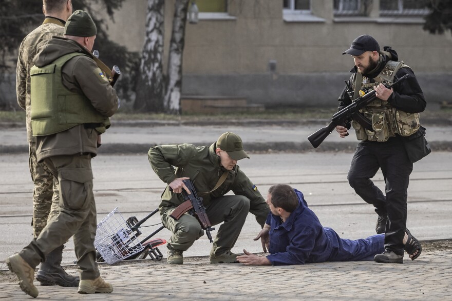 <strong>March 31:</strong> Ukrainian servicemen check passers-by after a bombardment in the city of Kharkiv, during Russia's invasion launched on Ukraine.