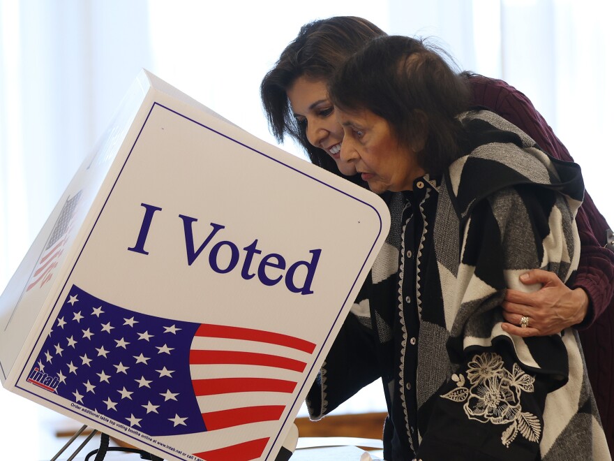 Republican presidential candidate former U.N. Ambassador Nikki Haley (L) helps her mother Raj Kaur Randhawa (R) cast her ballot in the South Carolina Republican primary on Saturday in Kiawah Island, S.C.
