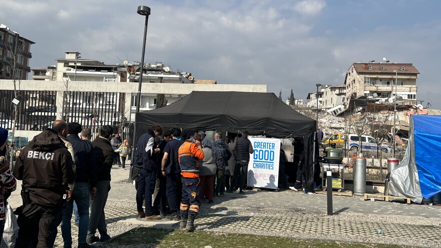 People displaced by the earthquake line up for food at a tent city in Antakya, in Turkey's central Hatay Province.