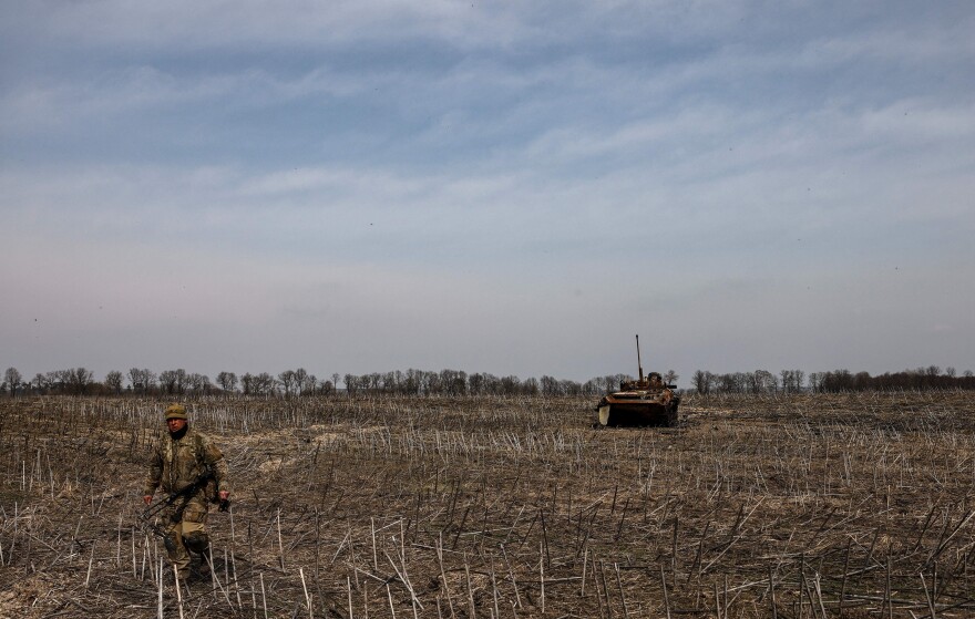 <strong>March 31:</strong> A Ukrainian soldier walk near the wreckage of a Russian tank on the outskirts of Kyiv, amid Russian invasion of Ukraine.