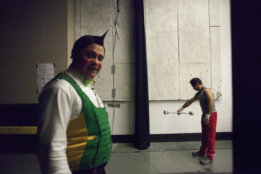 Clowns and trapeze artists loosen up backstage before the show.