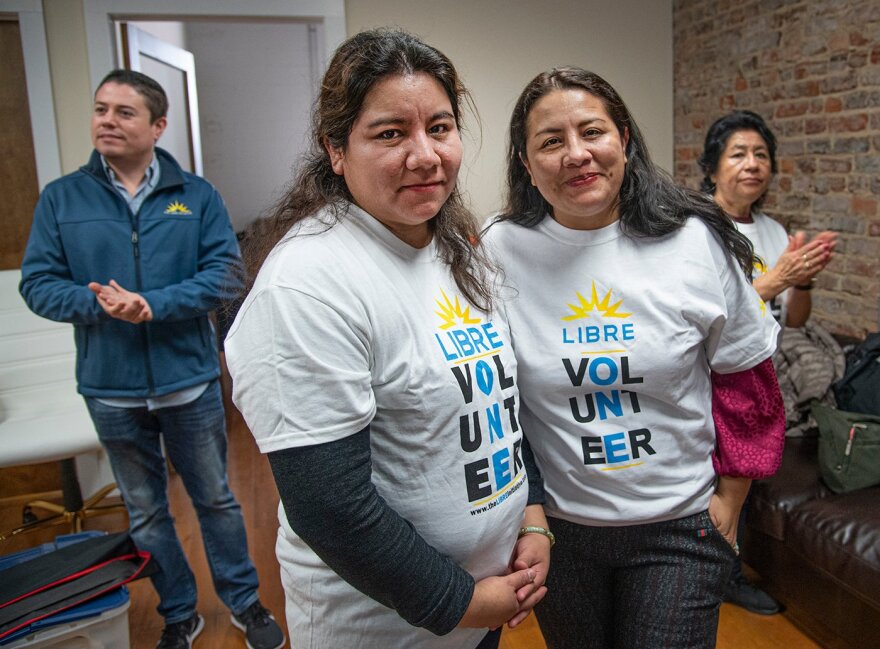 Two people wearing matching shirts that say "LIBRE VOLUNTEER
