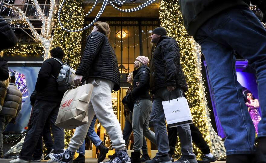 Shoppers carry bags down Fifth Avenue. (Julia Nikhinson/AP)