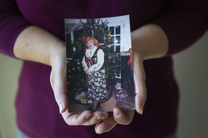Cassaro holds a photograph of her mother. "My mom died among strangers," she said.