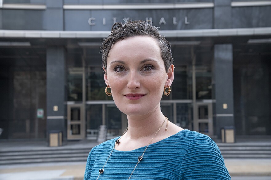 Eva Colen smiles into the camera outside of city hall.