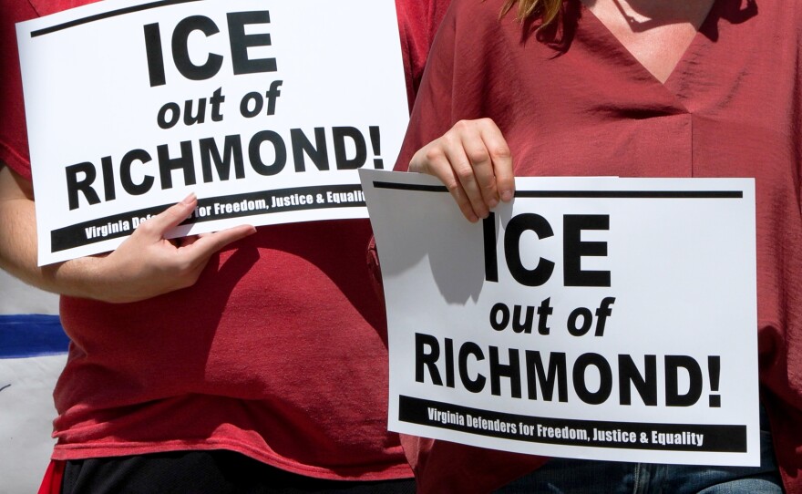 Two people in red shirts hold up signs reading "ICE out of RICHMOND!"