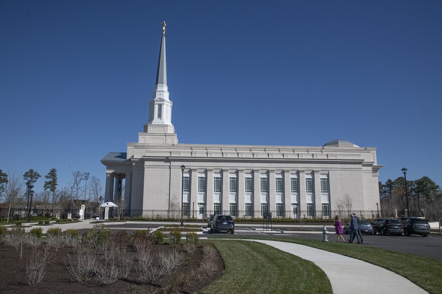 The side of a large building with columns and a tall steeple