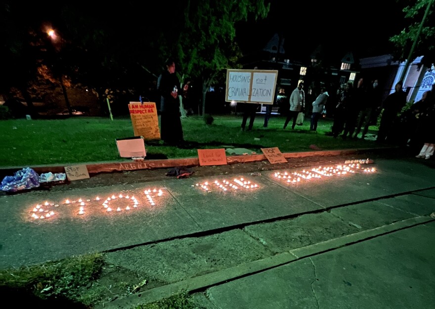 "Stop the sweep" is spelled out in tea light candles during a protest.