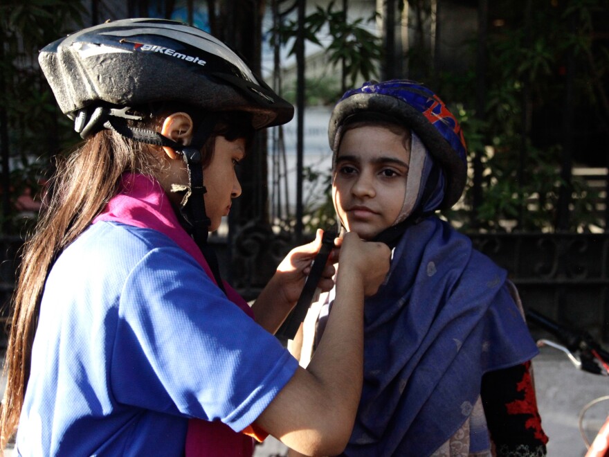 Members of the women's bike group don helmets before their ride.