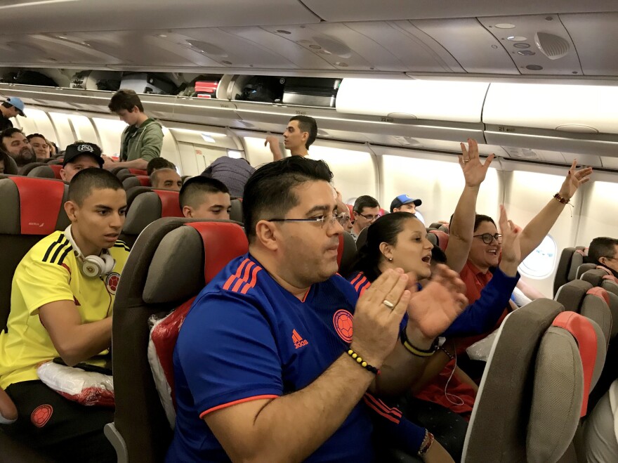 Soccer fans traveling from South America cheer after boarding a connecting red-eye flight from Madrid to Moscow.