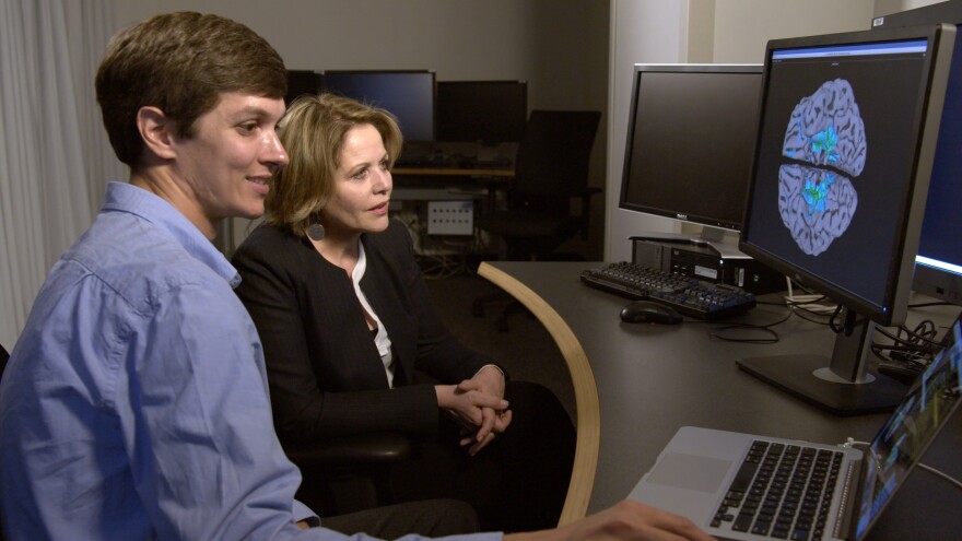 Singer Renee Fleming looks at a brain scan with NIH neuroscientist David Jangraw after singing in the MRI machine, at the National Institutes of Health in Bethesda, Md. in 2017.