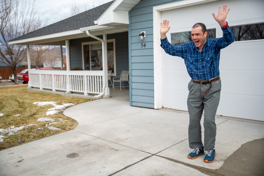 Domier waves to other residents of his group home as they leave the driveway.